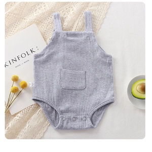 Detail of grey ribbed cotton baby romper featuring a small front pocket and snap buttons