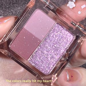 Vista macro di una palette di ombretti a quattro colori rosa e viola con texture opache e glitter