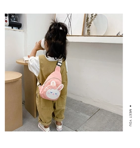 Detail of pink canvas bunny chest bag with sequin bow and adjustable strap on child