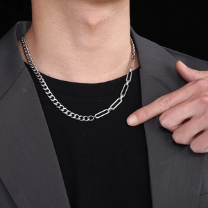 Detail of silver Cuban and paperclip link chain necklace worn on a male model