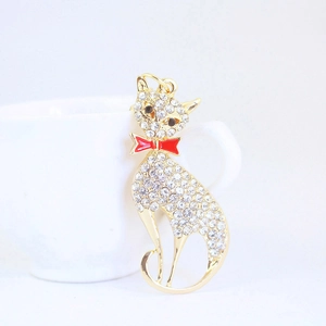 Sparkly rhinestone fox pendant keychain in gold finish hanging on a white ceramic cup