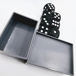 Overhead view of grey plastic storage case for magic dice set on white background