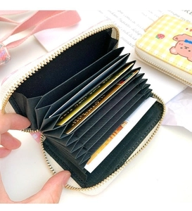 Detail of floral leather card holder with 11 accordion slots and gold zipper closure