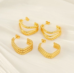 Detailed view of layered golden stainless steel earrings with woven and twisted textures