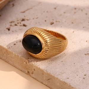 Detail of 18K gold-plated vintage ring featuring black onyx and crown pattern texture