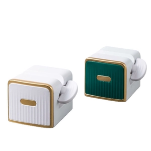 Rotating toothpaste squeezer in white and dark green colors with golden accents