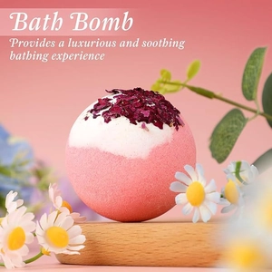 Close-up of pink and white handmade bath bomb with dried rose petals on wood