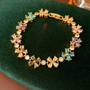 Detailansicht vergoldetes Kleeblatt Armband mit bunten Zirkonia Steinen auf Samt