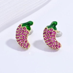 Macro view of chili pepper earrings with pink crystals and green enamel details