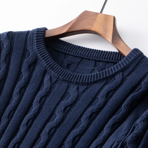 Detail of navy blue cable knit sweater showing round neck and premium cotton texture