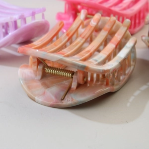 Macro view of orange marble pattern hair claw clip with durable metal spring detail