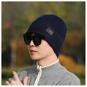 Detail of ribbed knit texture and black lettered label on the navy blue beanie