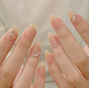 Detailed view of nude pink gradient press-on nails with sparkling rhinestones decoration