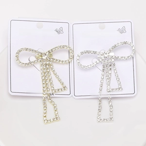 Close-up of golden and silver bow hair clips with rhinestones on display cards