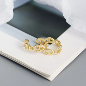 Macro shot of gold link ear cuff featuring sparkling rhinestones and a polished finish