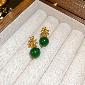 Detaillierte Nahaufnahme von Vintage Goldknoten-Ohrringen mit dunkelgrünen Harzperlen