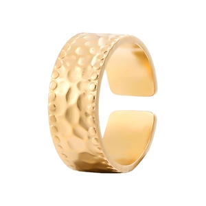 Detailed view of golden hammered texture on an adjustable open stainless steel ring