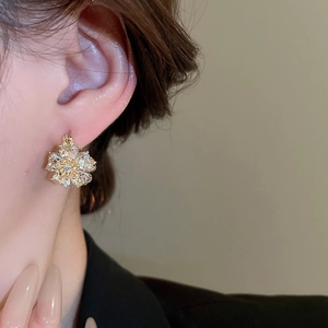Detailed side view of floral stud earrings featuring opal stones and diamond accents