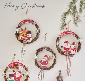 Detail of Christmas rattan wreaths with Santa, reindeer and snowman hanging on a white wall