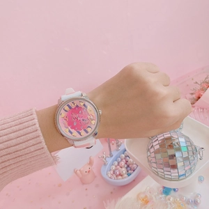 Close-up of pink and white silicone strap watch with golden heart hour markers