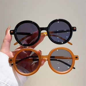 Détail de lunettes de soleil rondes rétro montrant la texture et les mesures sur la branche