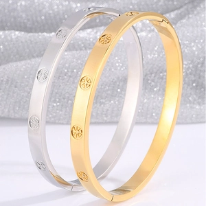 Detail of luxury gold and silver stainless steel bangles with radial star pattern engraving