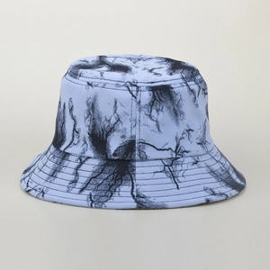 Close-up of the light blue bucket hat featuring black tie-dye patterns and reinforced stitching