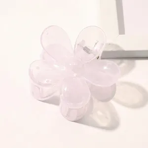Detail of a light pink translucent floral hair claw clip with a resin finish