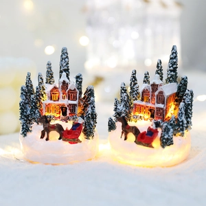 Illuminated resin Christmas snow house with pine trees and sleigh for holiday decor