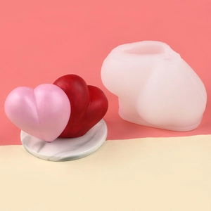 Detailed macro view of 3D double heart silicone mold and finished pink candle artwork