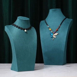 Teal velvet mannequin busts for jewelry display with pearl chokers on marble base