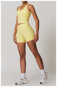 Dettaglio del set yoga giallo con top vogatore e pantaloncini a compressione