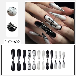 Gothic black and white press-on nails with silver cross studs and punk chrome details
