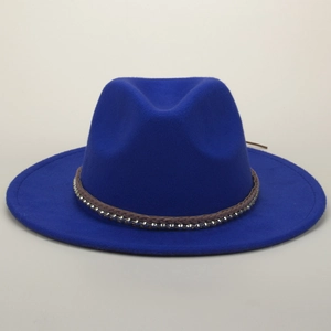 Royal blue fedora hat with brown braided band and silver studs on a clean grey background