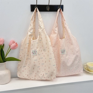 Detail of floral and animal print tote bags hanging with home decor background