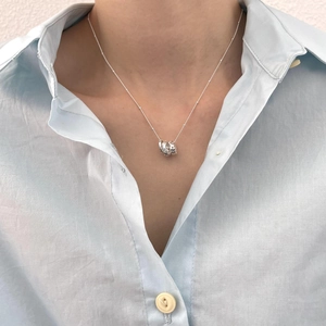 Close-up of elegant 925 silver necklace with geometric zircon pendant worn by a model