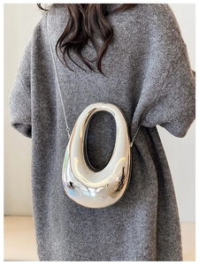 Silver metallic crossbody bag with sleek streamlined design and thin metal chain strap
