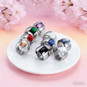 Detailed view of nine colorful square cut gemstones set in wide titanium steel ring bands