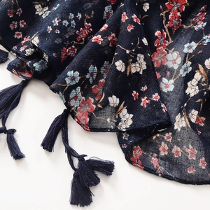 Detail of navy cotton-linen scarf with small floral patterns and blue tassel fringes