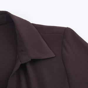 Détails de couture et texture du tissu sur le col d'une robe midi marron foncé de qualité