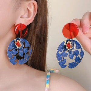 Elegant retro blue floral hollow earrings with red beads shown on an Asian model detail view