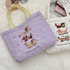 Detail of heart-quilted fabric tote bag with cute cat embroidery and soft handles