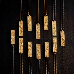 Collection of 12 zodiac tarot necklaces in 18K gold plated finish on dark stone