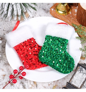 Close-up of red and green sequin Christmas stockings with faux fur trim on a festive tray