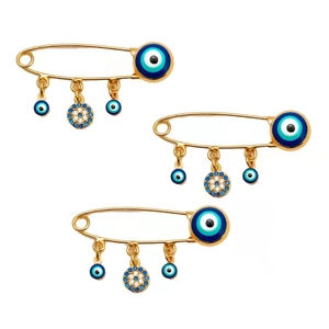 Close-up of three golden Evil Eye brooches with blue crystals on white background