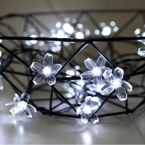 Close-up of LED solar cherry blossom fairy lights wrapped in a black metal wire basket