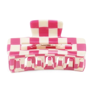 Detail of checkered hair claw clip in rose red and cream white with high-gloss finish