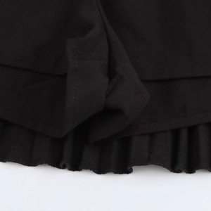 Detail shot of black wide-pleated fabric hem showcasing high-quality stitching and texture