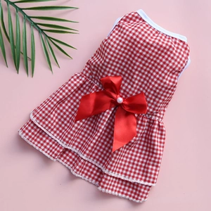 Detail of red and white checkered pet dress with silk bow and pearl buttons on pink base