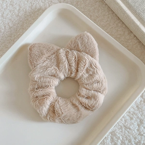 Close-up of fluffy cat ear scrunchie in khaki faux rabbit fur on a white tray